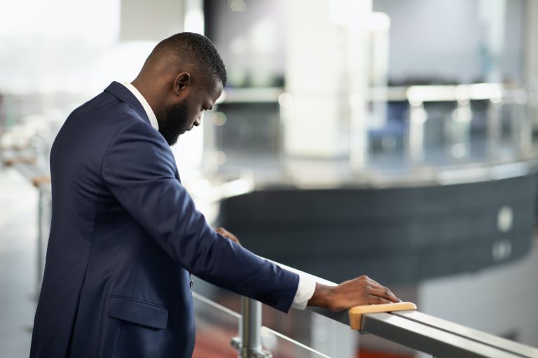 Stressed african american entrepreneur standing by railing